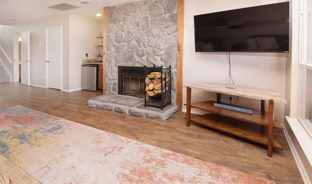 a living room with furniture a flat screen tv and a fireplace