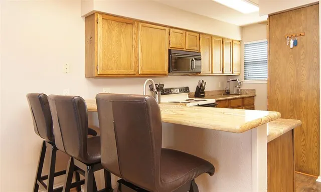 a kitchen with a table chairs sink and cabinets
