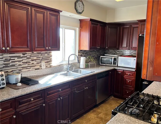 a kitchen with stainless steel appliances granite countertop a sink stove and cabinets