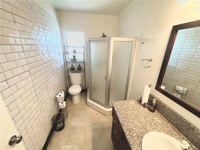 a bathroom with a granite countertop sink toilet and shower