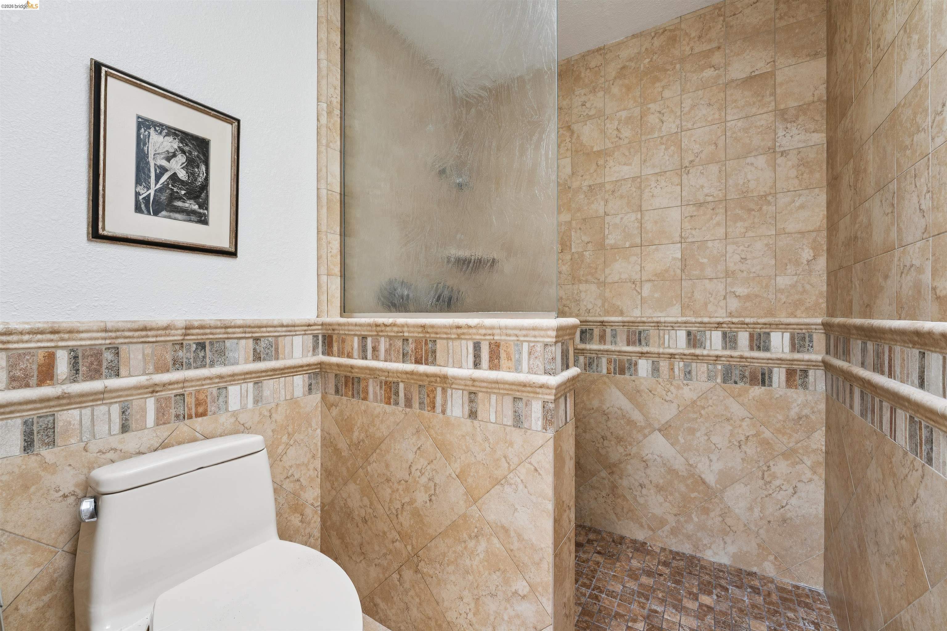 7 Jo Lin Court El Sobrante, CA 94803 - Photo 75 of 99 Bathroom featuring a glass-enclosed shower, tiled walls, and a tiled shower floor