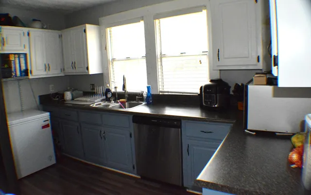 a kitchen with a window a sink and cabinets