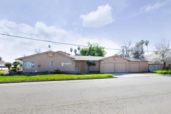 a house with a yard and a car parked in front of it