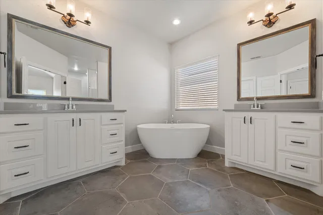 a spacious bathroom with a bathtub sink and mirror