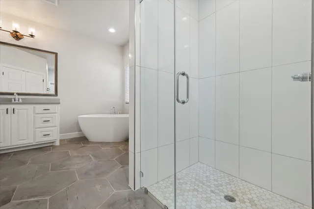 a spacious bathroom with a bathtub sink and mirror