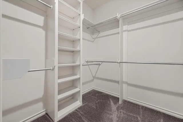 a view of walk in closet with empty racks