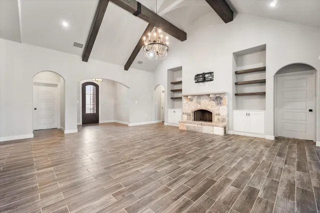 a view of empty room with fireplace and wooden floor