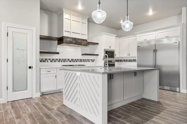 a kitchen with stainless steel appliances granite countertop a sink a stove and a refrigerator