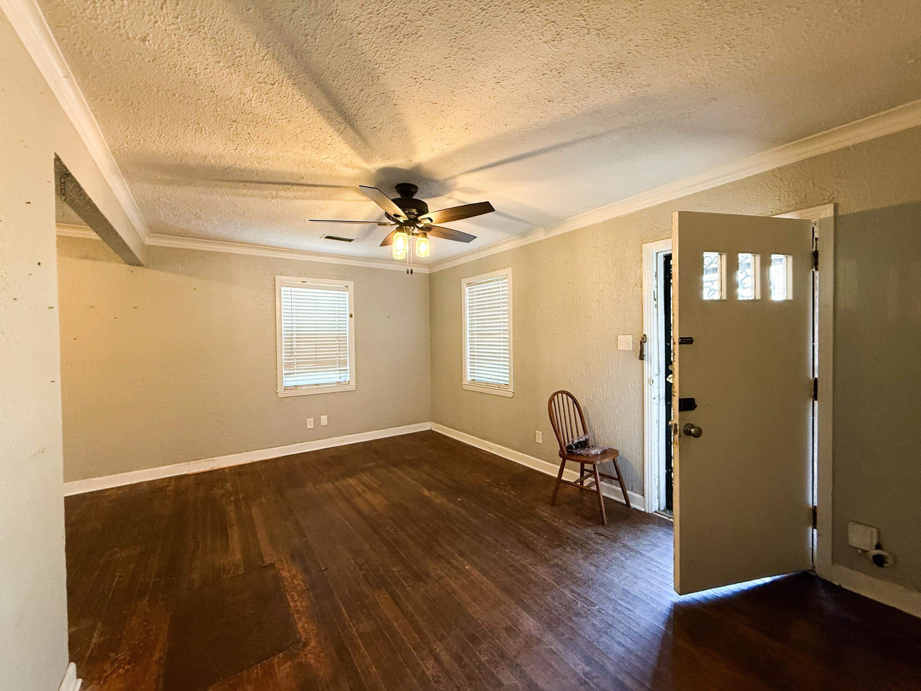 1027 Waring Road Memphis, TN 38122 - Photo 6 of 14 Entrance foyer with dark wood-style floors, a textured wall, ceiling fan, a textured ceiling, and crown molding