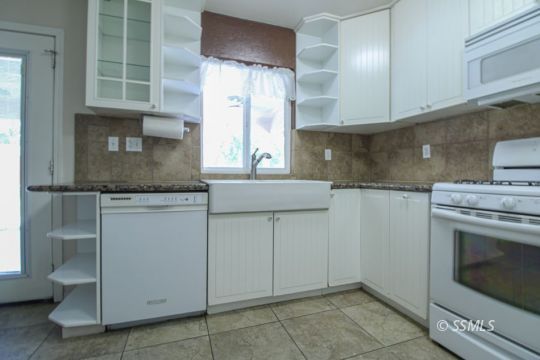 1043 Peg Street Ridgecrest, CA 93555 - Photo 13 of 45 a kitchen with granite countertop a sink and a stove