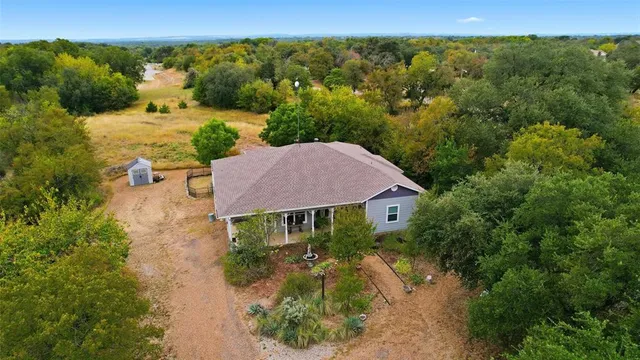 an aerial view of a house with yard and green space