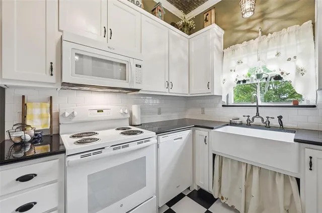 a kitchen with cabinets appliances a sink and a window