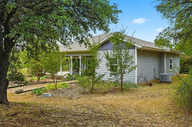 a backyard of a house with barbeque oven table and chairs