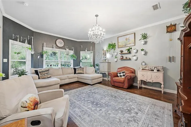 a living room with furniture and a chandelier