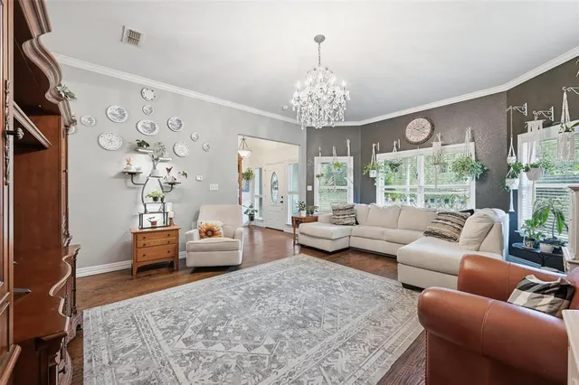 a living room with furniture or chandelier and a wooden floor