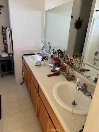 a bathroom with double vanity sinks and a mirror