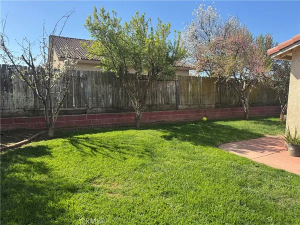 a view of yard with grass and wooden fence
