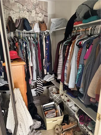 a view of walk in closet with clothes and shoes