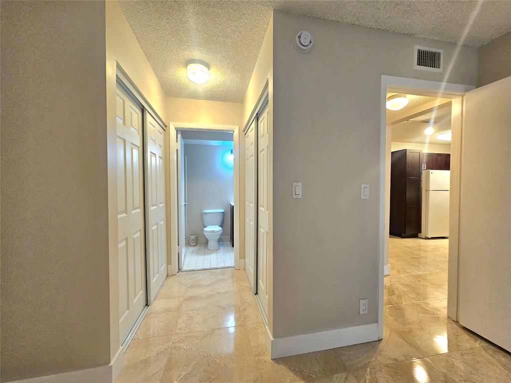 631 Lyons Road, Unit 12105 Coconut Creek, FL 33063 - Photo 8 of 26 a view of a hallway with wooden floor