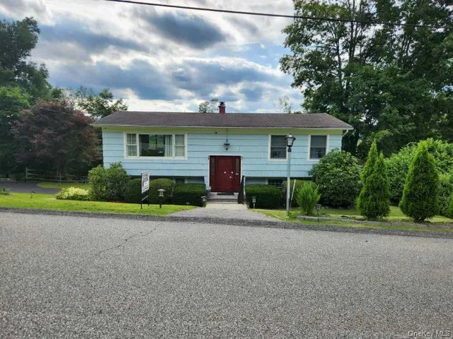 a view of a house with a yard and palm trees