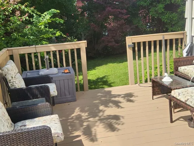 a roof deck with couches and wooden floor