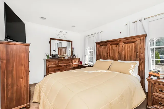 a bedroom with a bed and a flat screen tv