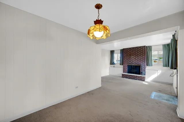 an empty room with a fireplace and a window