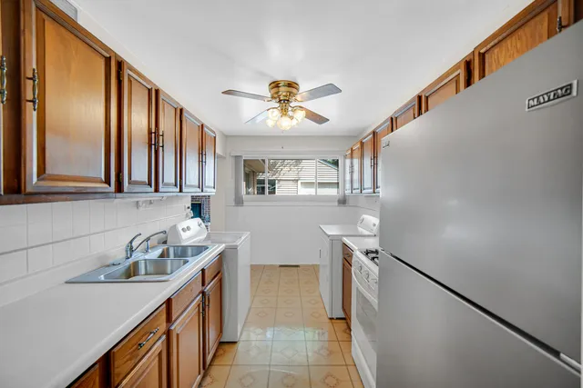 a kitchen with stainless steel appliances granite countertop a sink and a refrigerator