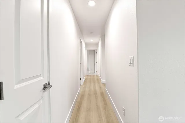 a view of a hallway with wooden floor