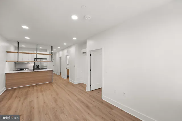 a large kitchen with a lot of counter space and wooden floor