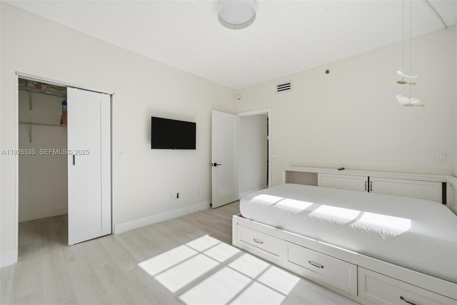 3255 Northeast 184th Street, Unit 12210 Aventura, FL 33160 - Photo 15 of 17 a bedroom with a bed and a flat screen tv
