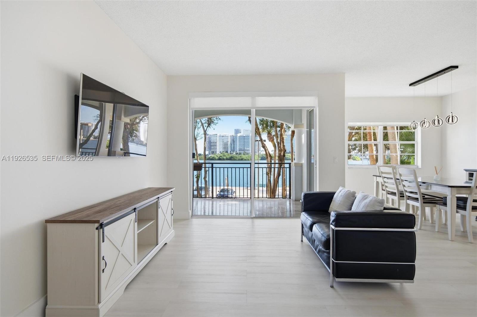 3255 Northeast 184th Street, Unit 12210 Aventura, FL 33160 - Photo 3 of 17 a living room with furniture and a flat screen tv