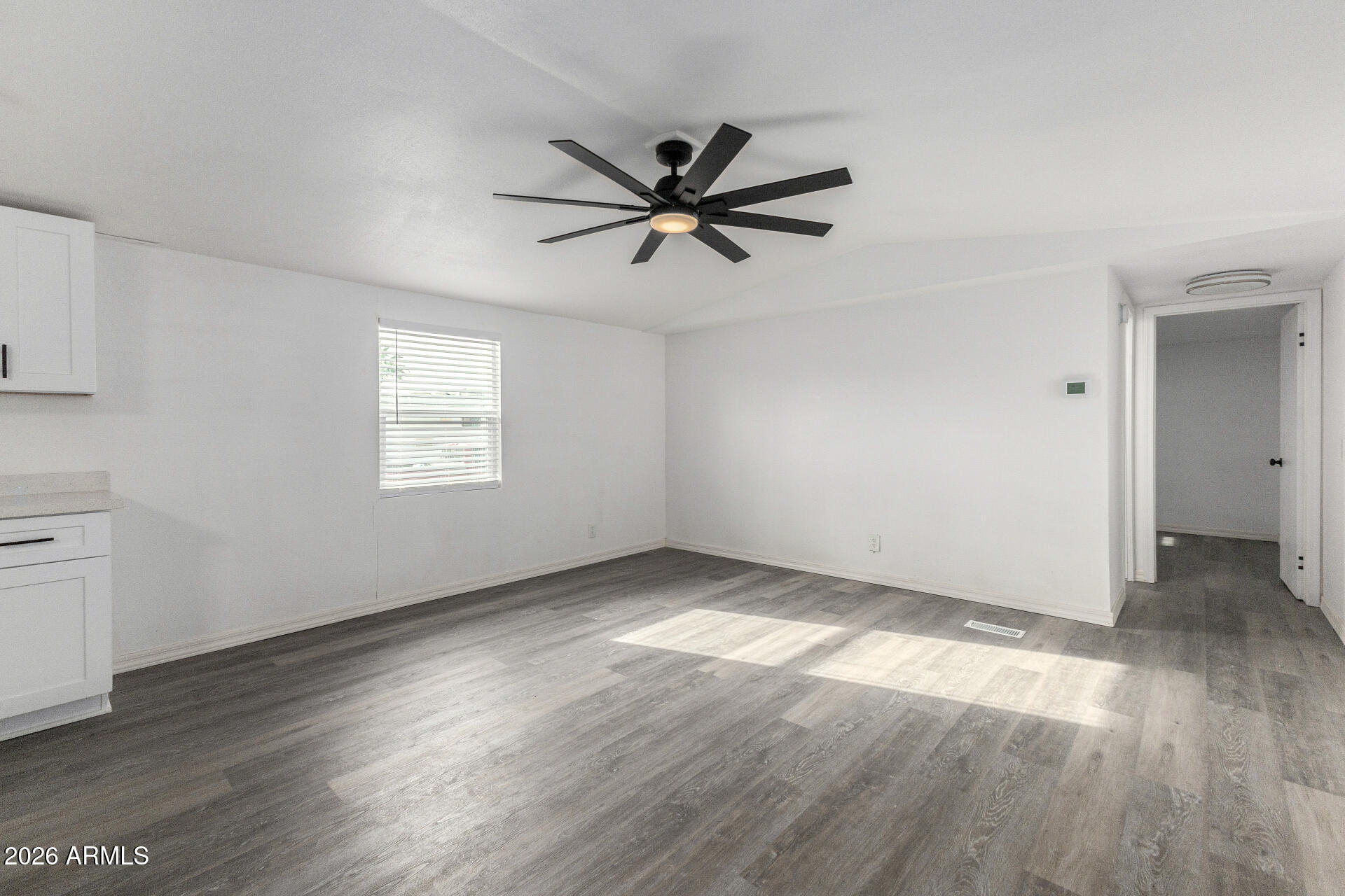 555 West Warner Road, Unit 125 Chandler, AZ 85225 - Photo 12 of 29 an empty room with wooden floor fan and windows