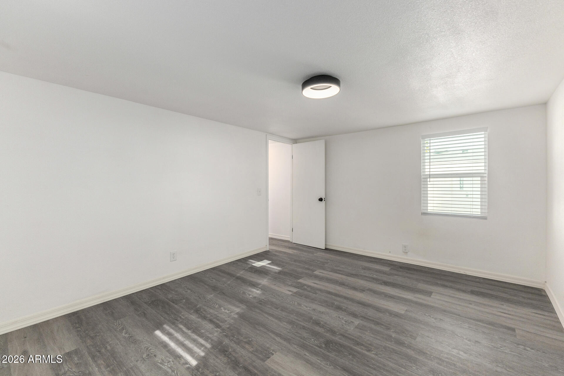 555 West Warner Road, Unit 125 Chandler, AZ 85225 - Photo 17 of 29 an empty room with wooden floor and windows