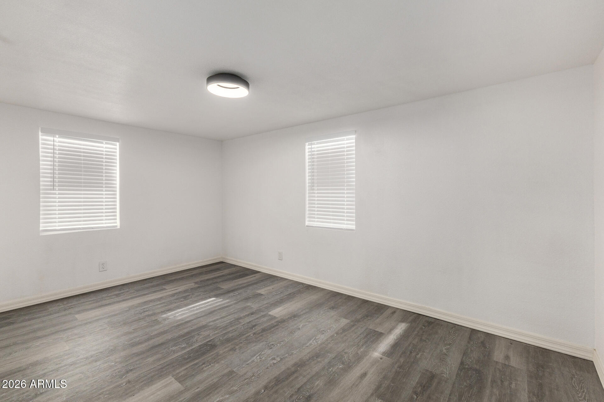 555 West Warner Road, Unit 125 Chandler, AZ 85225 - Photo 22 of 29 an empty room with wooden floor and windows