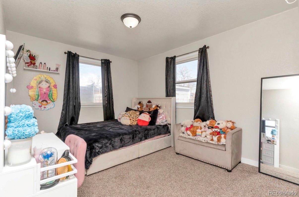 9271 Travis Street Thornton, CO 80229 - Photo 13 of 25 a bed room with furniture and a bed