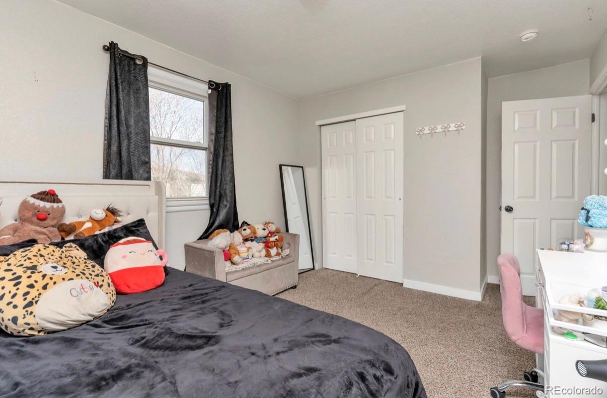 9271 Travis Street Thornton, CO 80229 - Photo 14 of 25 a bedroom with a bed and a dresser