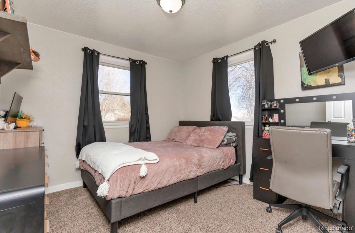 9271 Travis Street Thornton, CO 80229 - Photo 15 of 25 a bedroom with a bed window tv and television