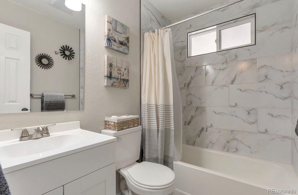 9271 Travis Street Thornton, CO 80229 - Photo 16 of 25 a bathroom with a sink a toilet and shower