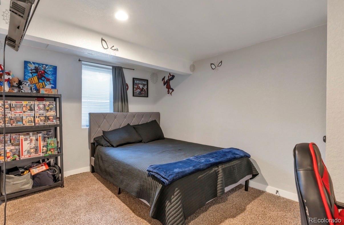 9271 Travis Street Thornton, CO 80229 - Photo 18 of 25 a bedroom with a bed and lots of books on the wall