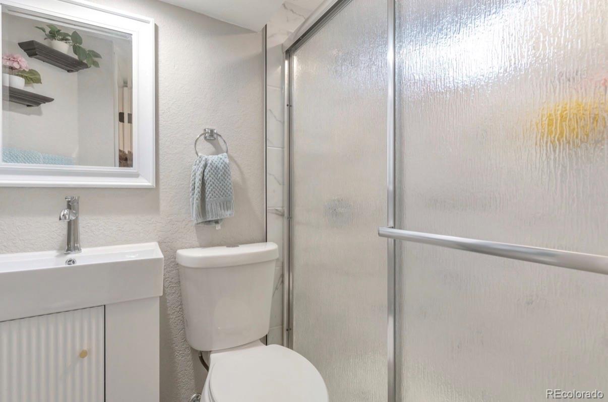 9271 Travis Street Thornton, CO 80229 - Photo 22 of 25 a bathroom with a sink a toilet and shower