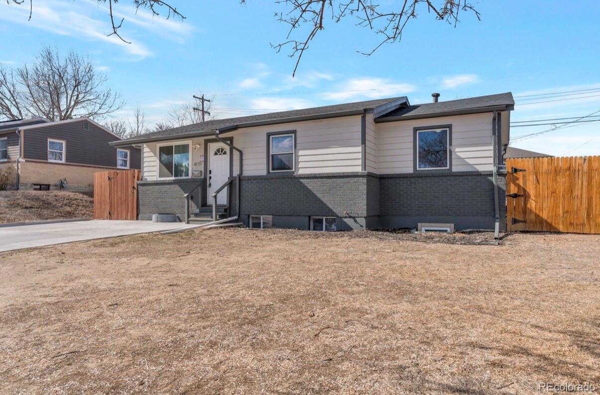 9271 Travis Street Thornton, CO 80229 - Photo 3 of 25 a front view of a house with a yard and garage