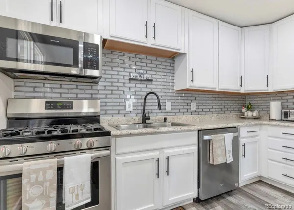 a kitchen with white cabinets stainless steel appliances and sink