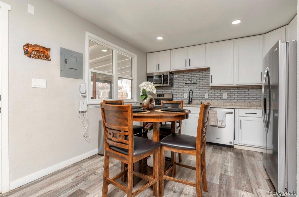 9271 Travis Street Thornton, CO 80229 - Photo 5 of 25 a kitchen with a table chairs refrigerator and microwave