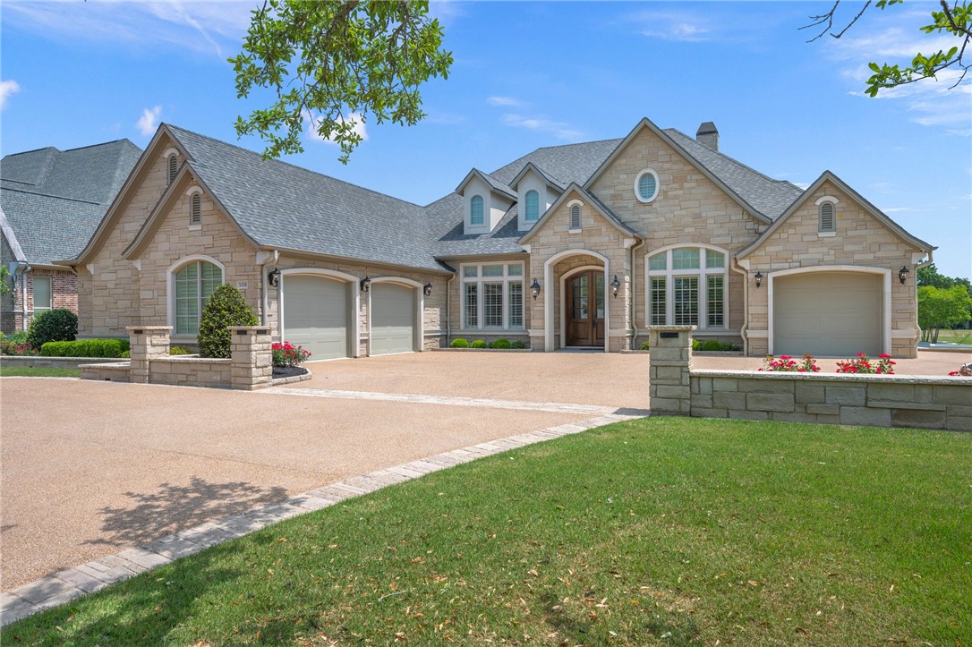 a front view of a house with a garden and yard