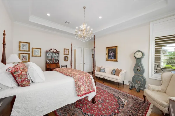 a spacious bedroom with a bed and a chandelier