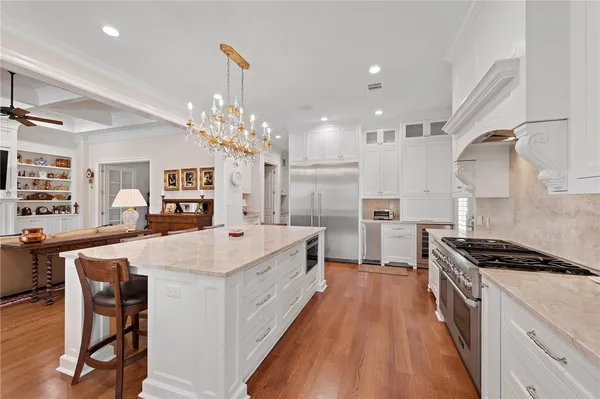 a large white kitchen with stainless steel appliances