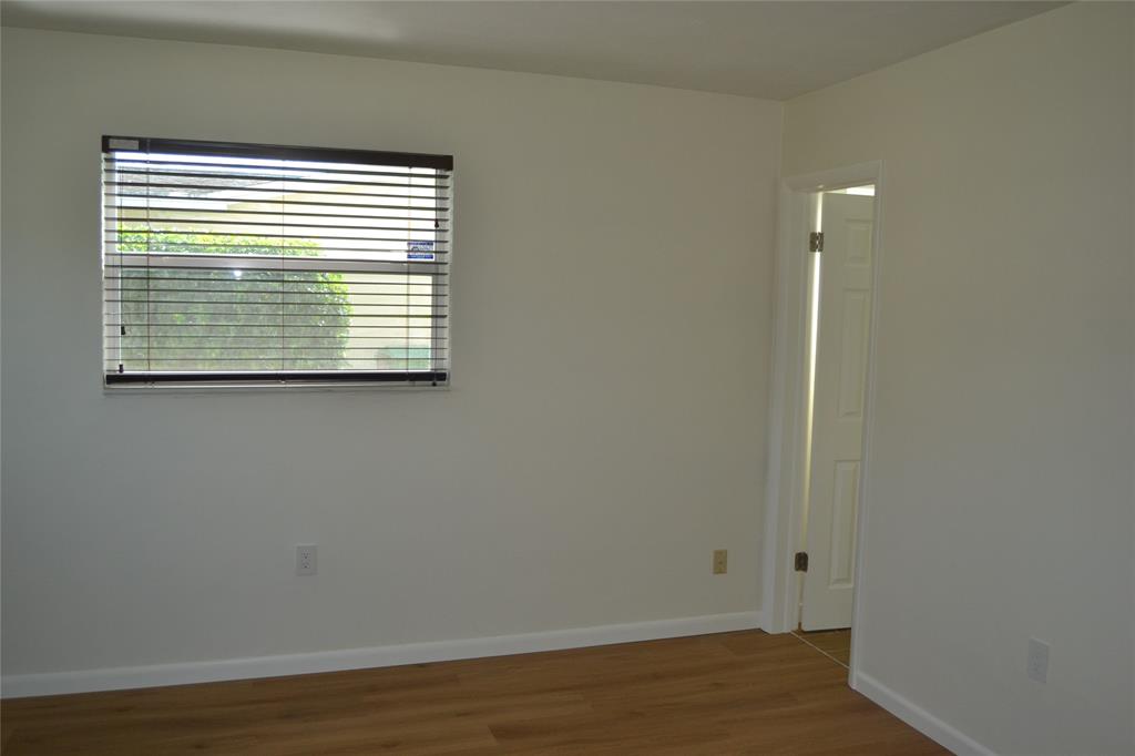 5241 Southwest 89th Avenue Cooper City, FL 33328 - Photo 14 of 28 a view of an empty room with wooden floor and a window