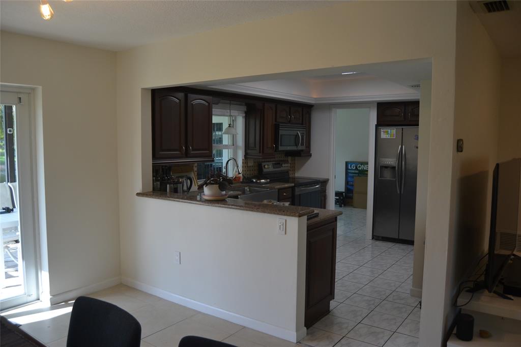 5241 Southwest 89th Avenue Cooper City, FL 33328 - Photo 9 of 28 a kitchen with stainless steel appliances granite countertop a refrigerator and a sink