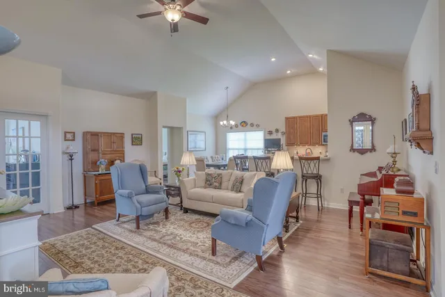 a view of a patio with couches table and chairs under an umbrella